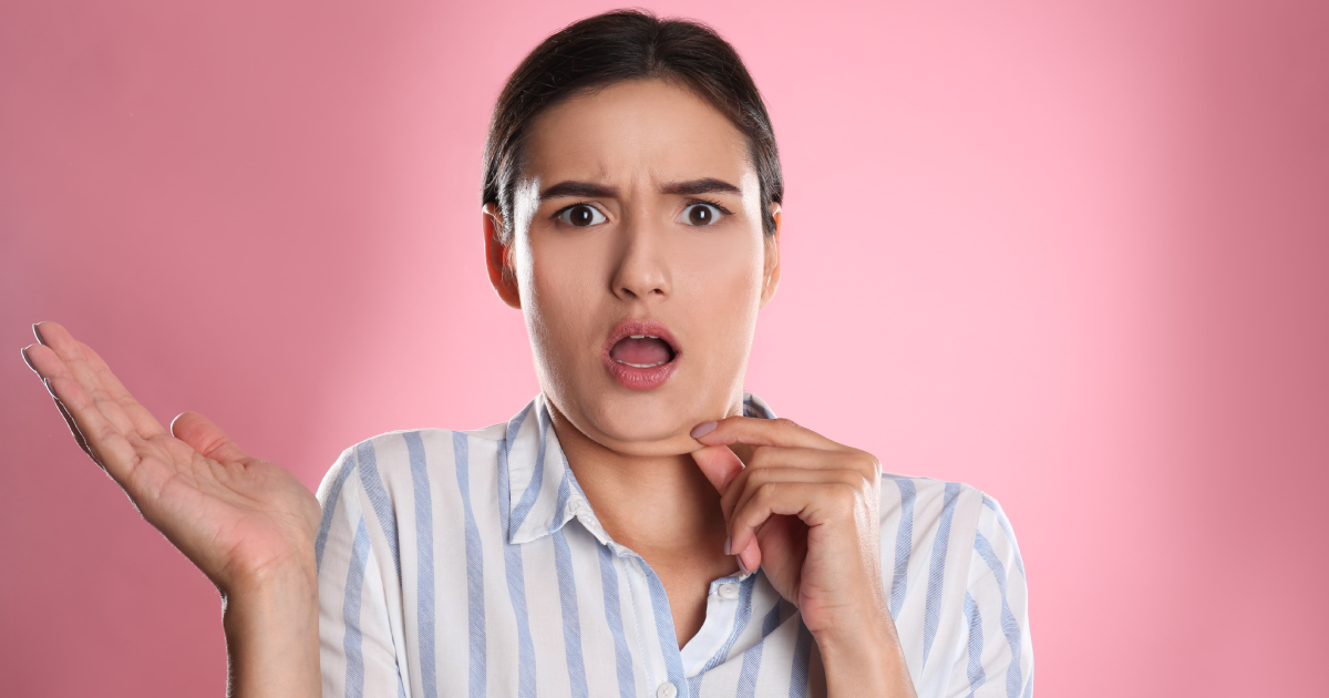 Surprised woman touching chin before Kybella Injections in Plainview, NY