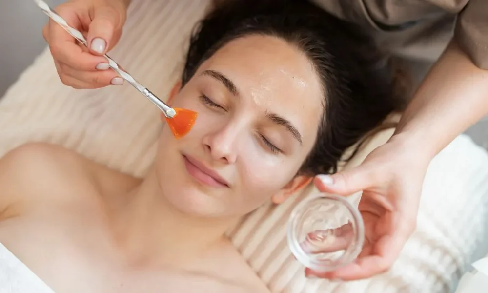 A woman receiving a VI Peel facial treatment from a technician in Plainview, NY